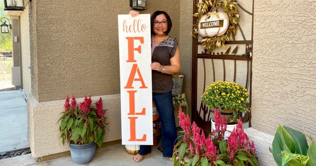 woman holding DIY hello fall porch sign