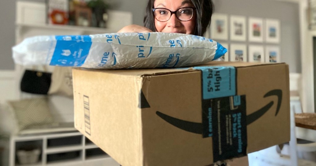 Woman holding packages with Amazon logo