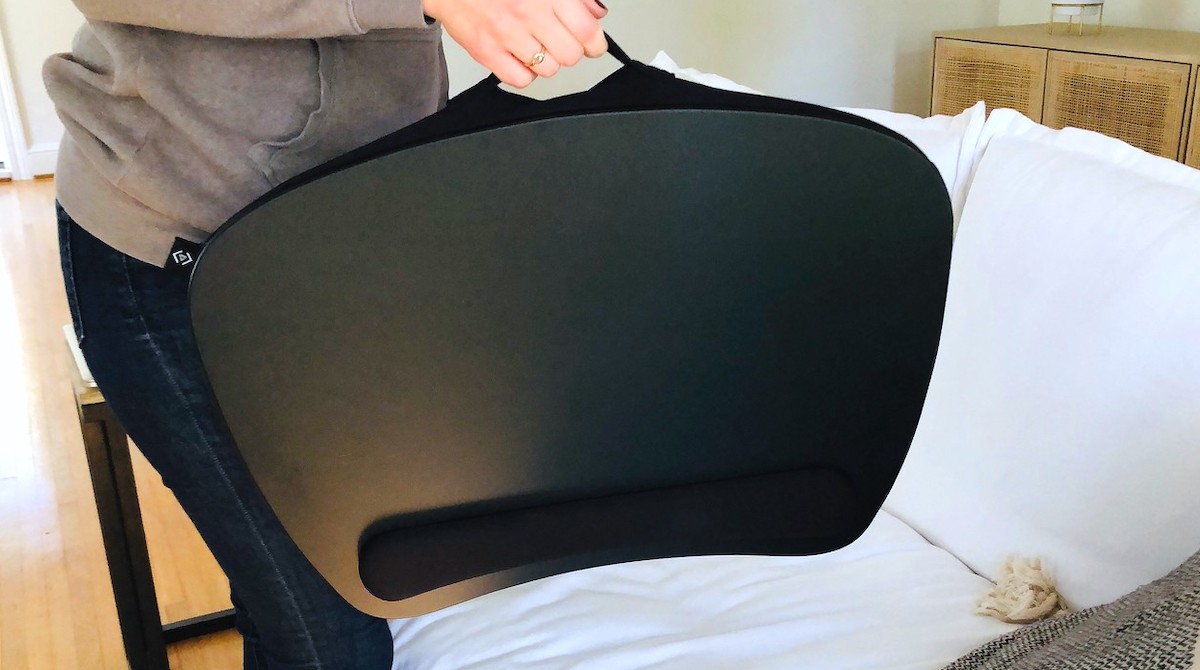 person holding up black lap desk 