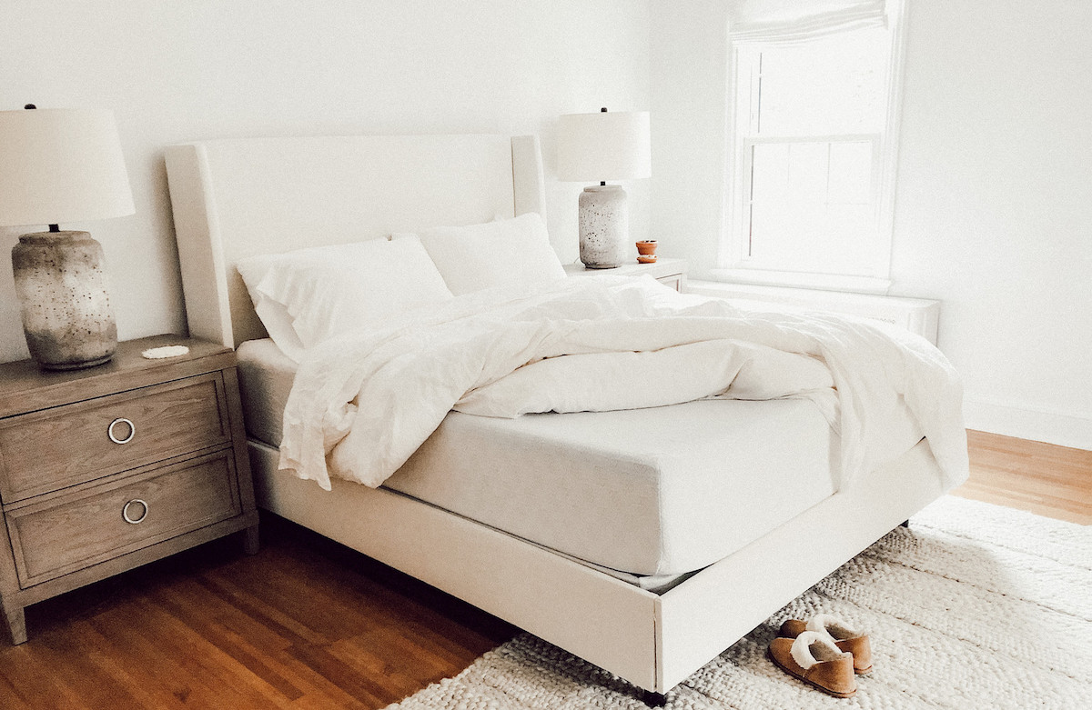 white bedding with corner of mattress pulled up