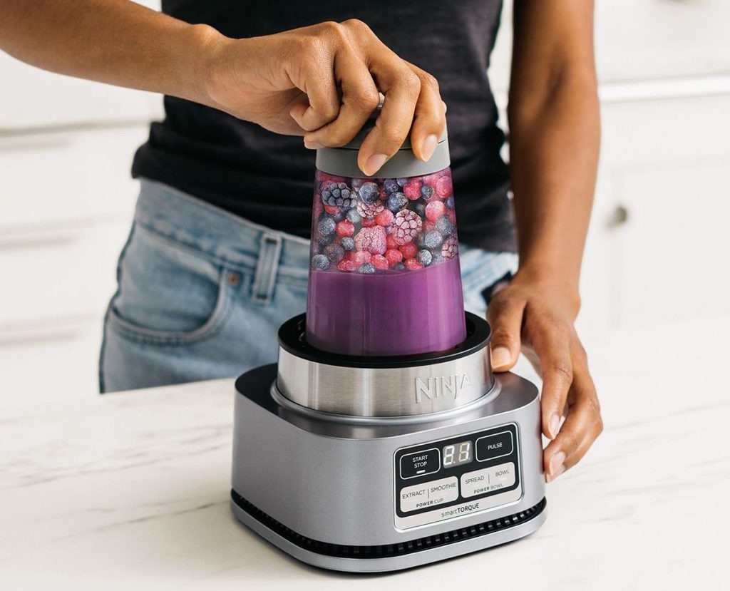 woman making smoothie with ninja foodi smoothie bowl maker