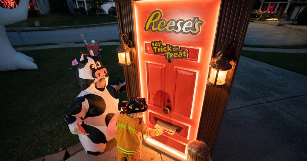 costumed children getting candy from Reese's Trick or Treat door