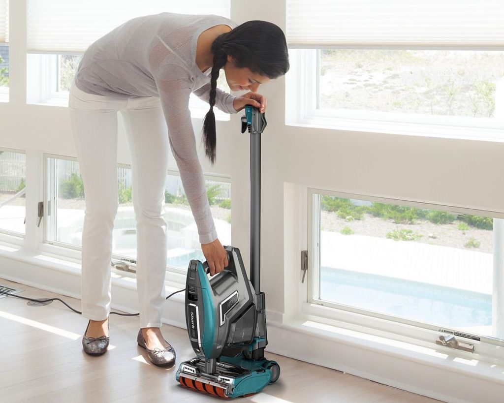 women bending over to clean with vacuum