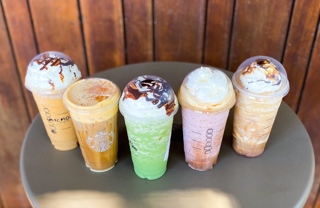 top view of various flavors of starbucks halloween secret menu drinks on table