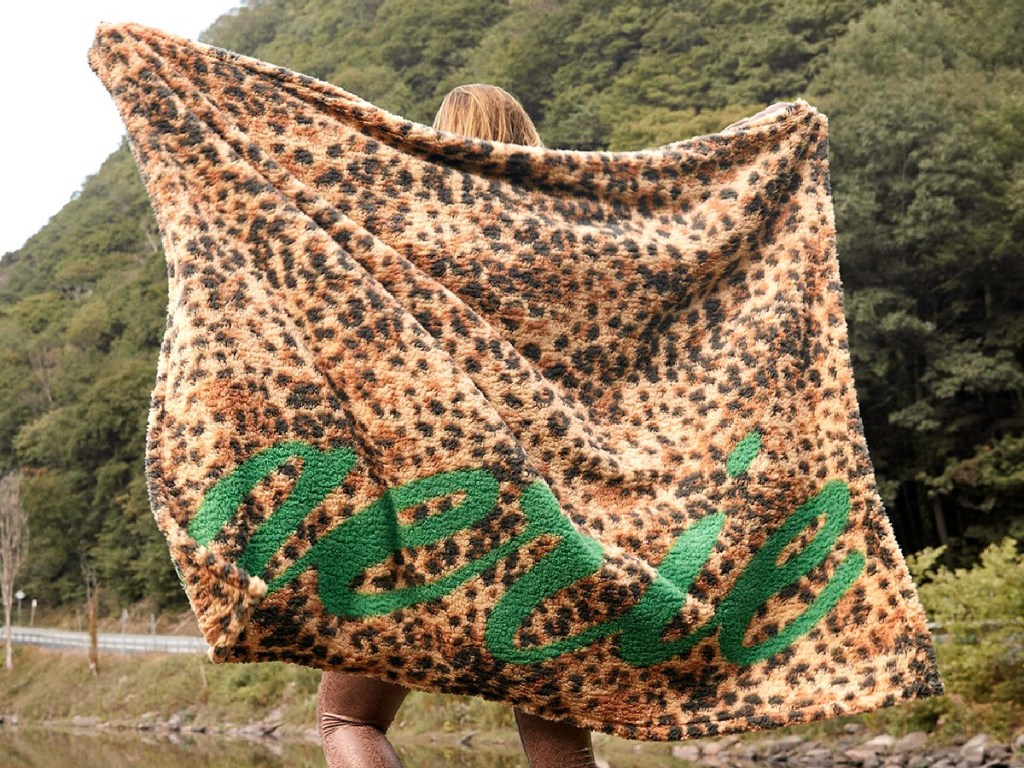 woman outdoors holding animal print blanket