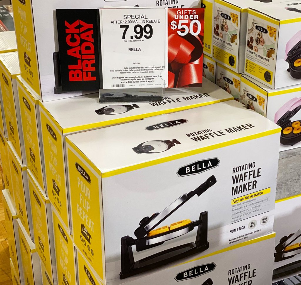 white and yellow boxes of Bella brand rotating waffle makers stacked with macy's $7.99 sale sign on top of them