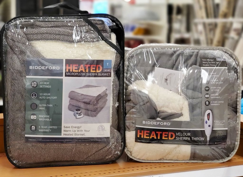 two heated sherpa blankets on wood shelf at store