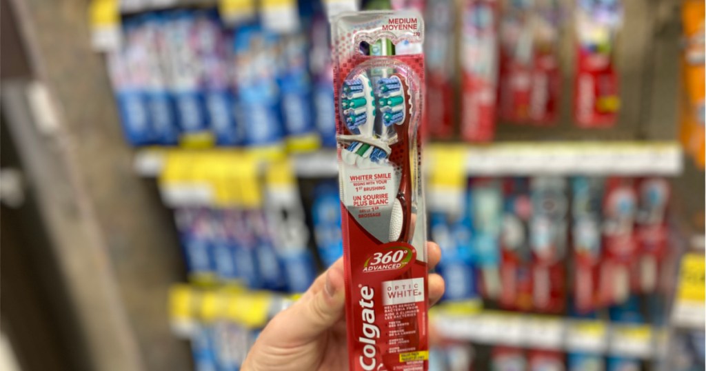 hand holding colgate toothbrush