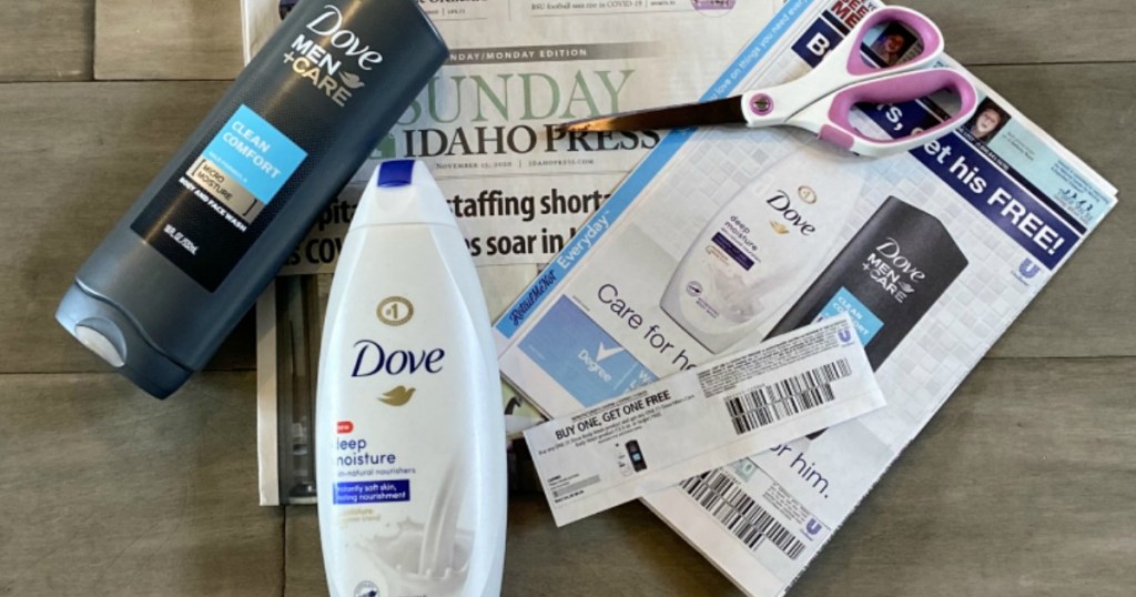 Buy 1 Get 1 Free Dove Body Wash Coupon on top of newspaper with scissors