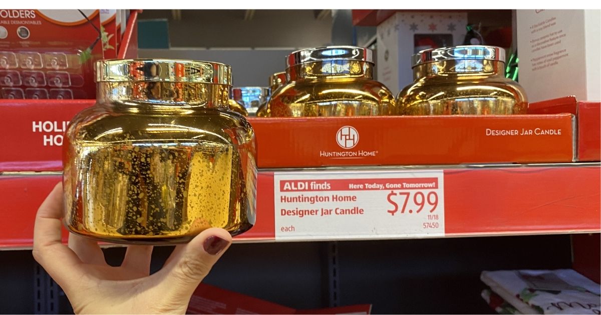 hand holding a gold glass jar candle in ALDI