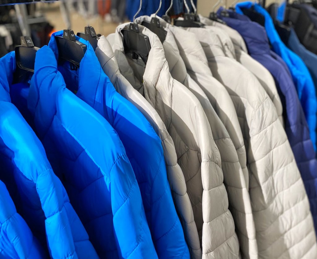 bright blue and light grey puffer jackets on hangers