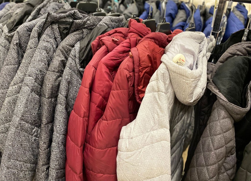 grey, maroon, and white colored puffer jackets on hangers