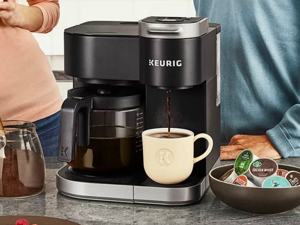 Keurig brewer with coffee mug near family in kitchen