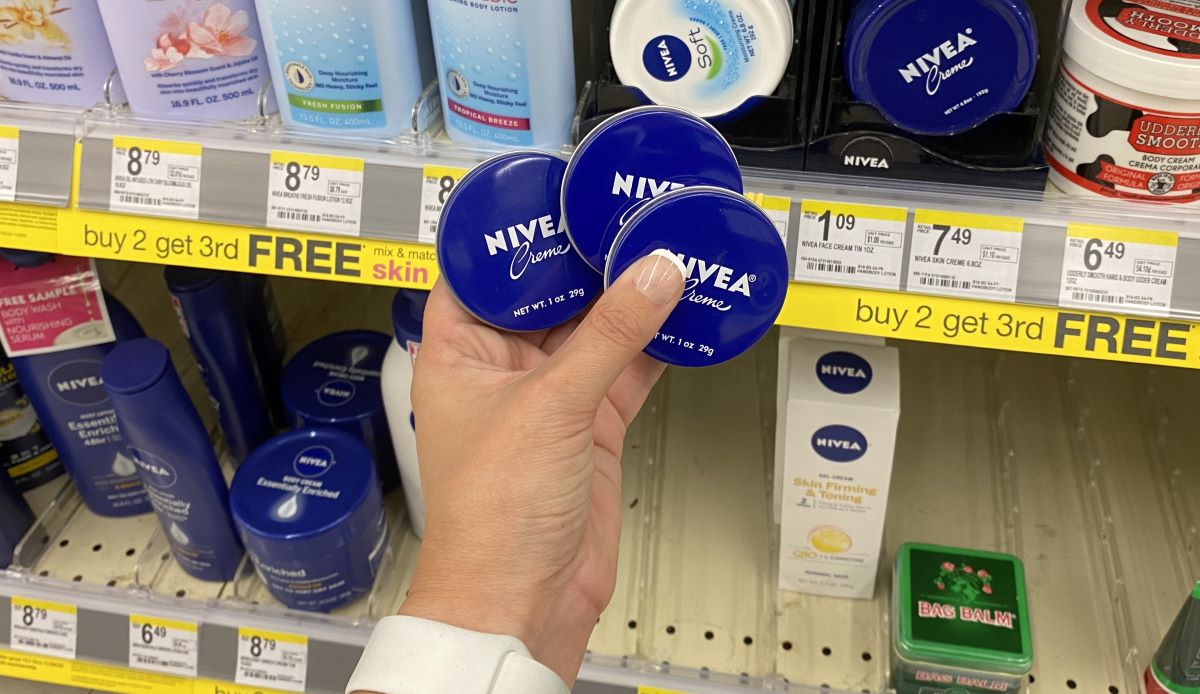 hand holding 3 NIVEA creme tins