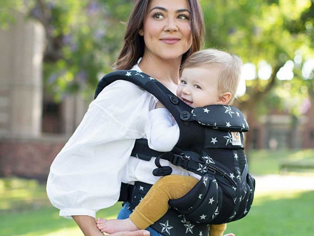 woman wearing blue and stars baby carrier