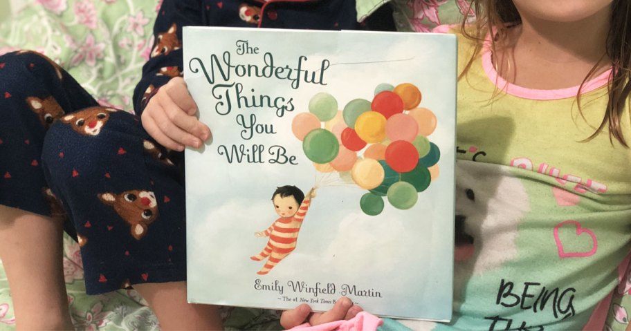 boy and girl holding up The Wonderful Things You Will Be hardcover book