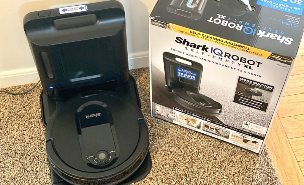 A shark vacuum on carpet next to the original box