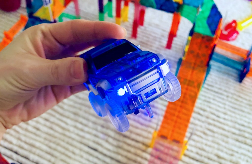 hand holding blue toy truck with lights on