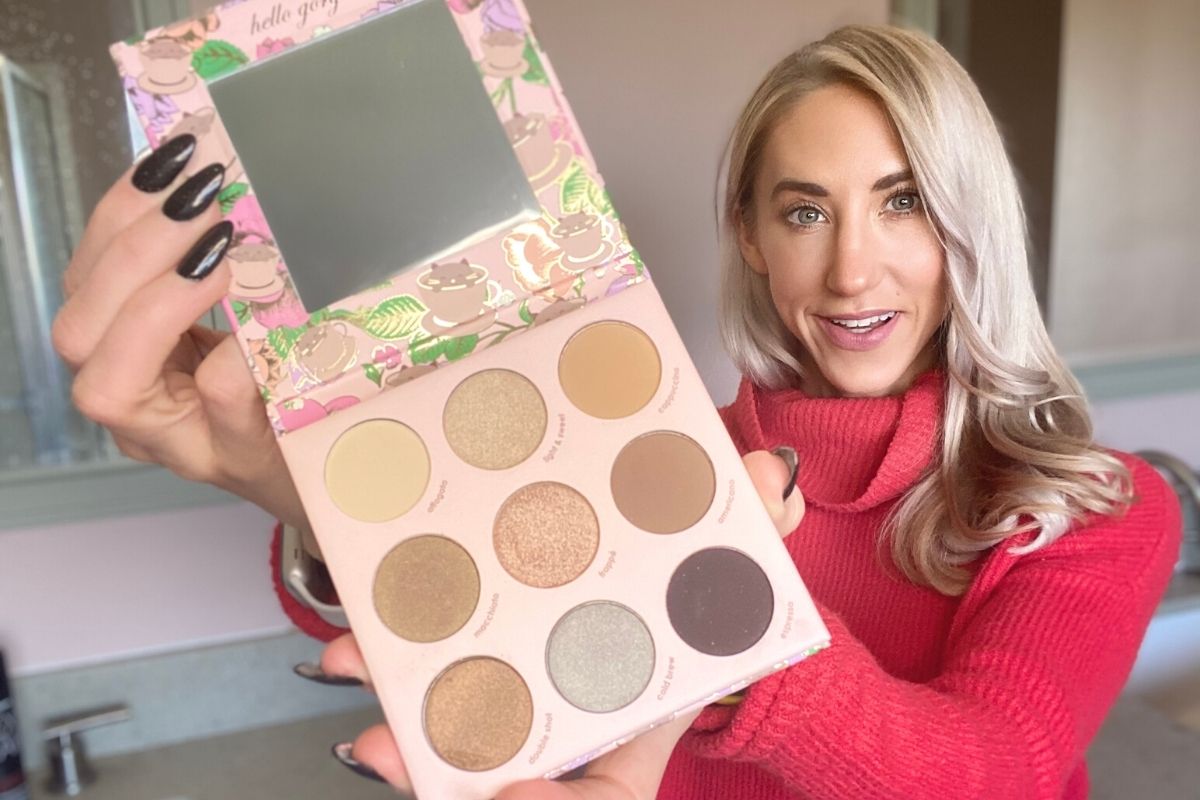 A woman holding a Winky Lux eyeshadow palette