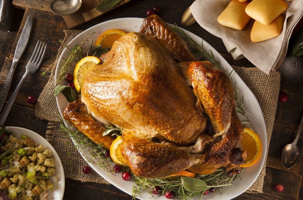 Thanksgiving turkey on platter with stuffing and rolls