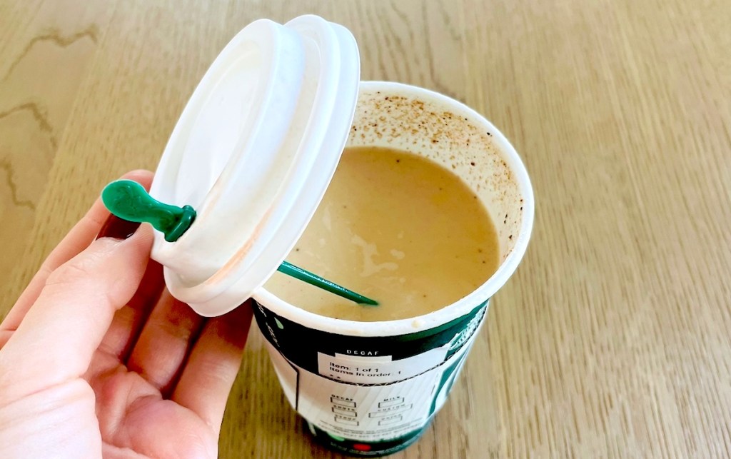 hand holding starbucks gingerbread latte lid looking inside drink