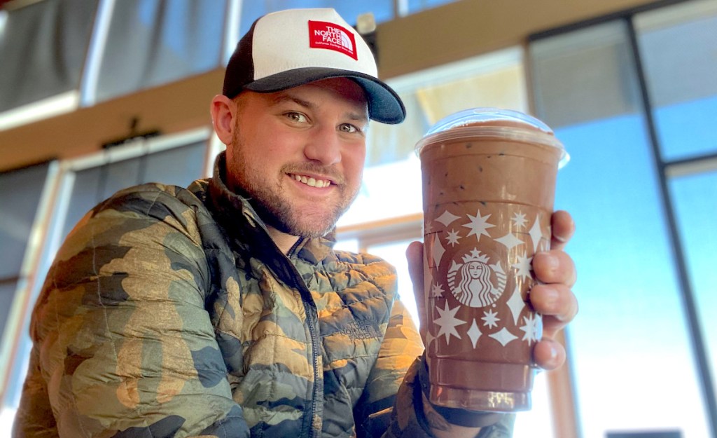 man holding a starbucks cup of hot cocoa cold brew