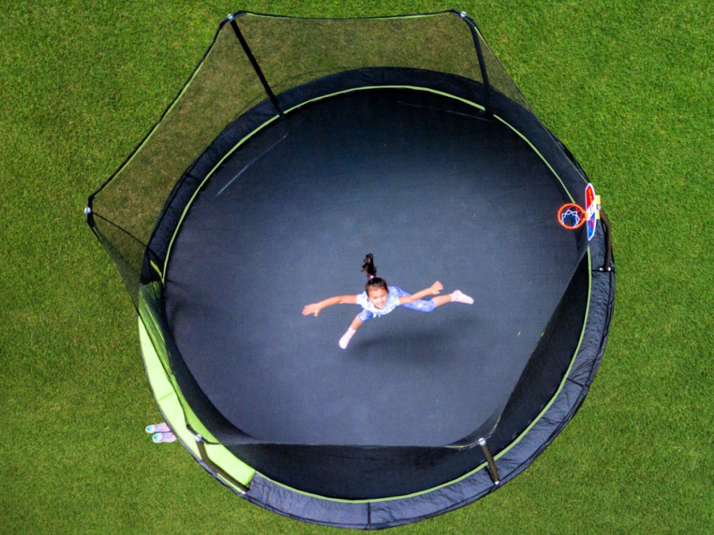 kid jumping on a Jump King 14ft Trampoline With Basketball Hoop