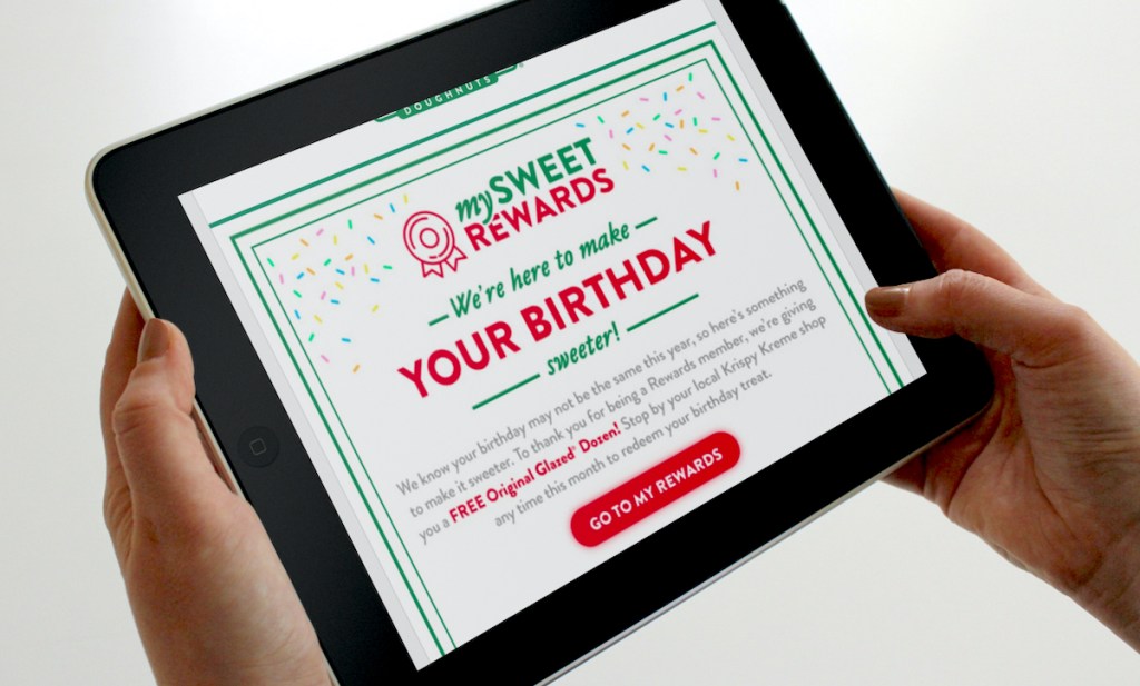 hand holding an ipad with krispy kreme birthday freebie dozen donuts