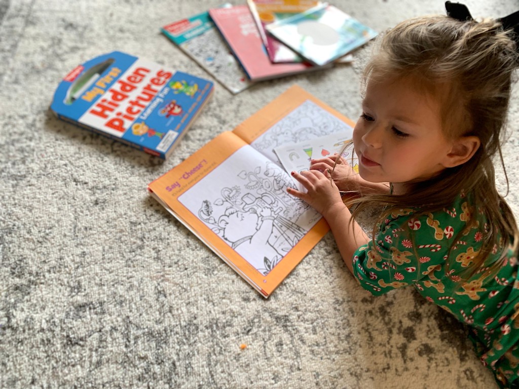 little girl playing with Highlights books 