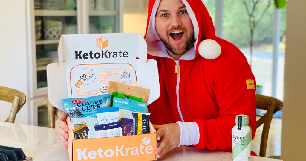 man in christmas pajamas holding a keto krate