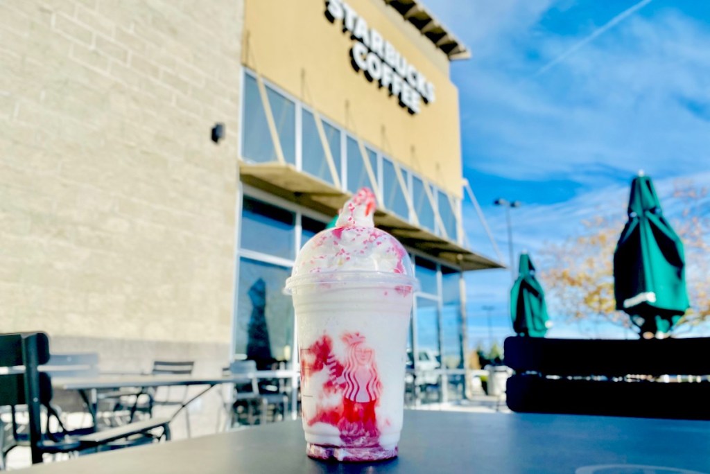 starbucks christmas frappuccino sitting on table outside