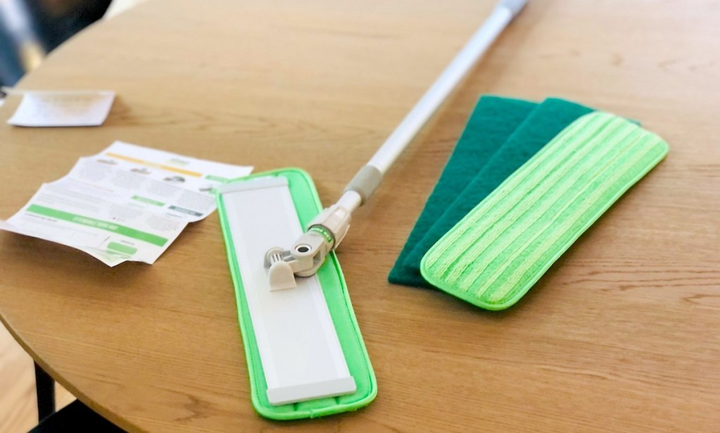 turbo mop with extra cleaning pads laying on wood table