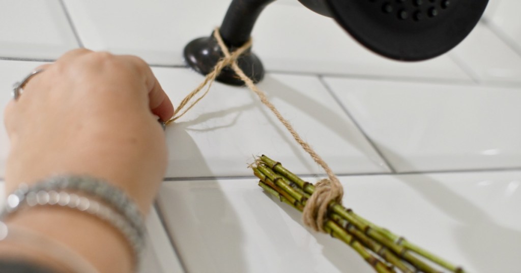 tying eucalyptus bouquet to shower head