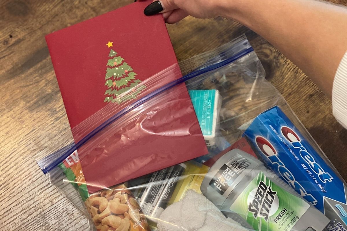 A hand placing a card inside a Ziploc bag