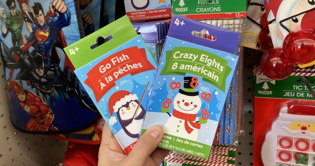 Woman holding two packs of kids Christmas theme card games