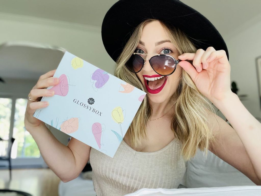 woman wearing sunglasses and holding a GlossyBox