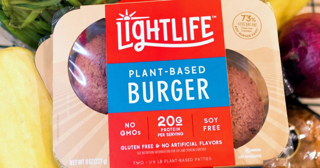 lightlife meatless burgers sitting on top of fresh vegetables