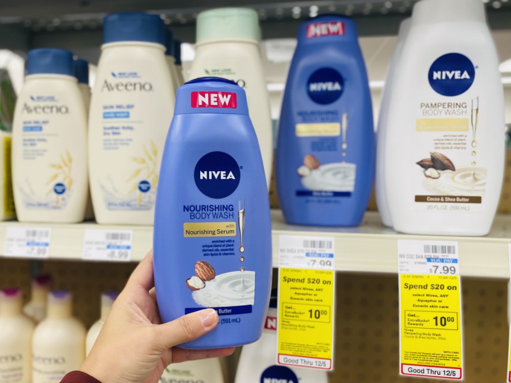 hand holding large bottle of body wash in front of store shelf