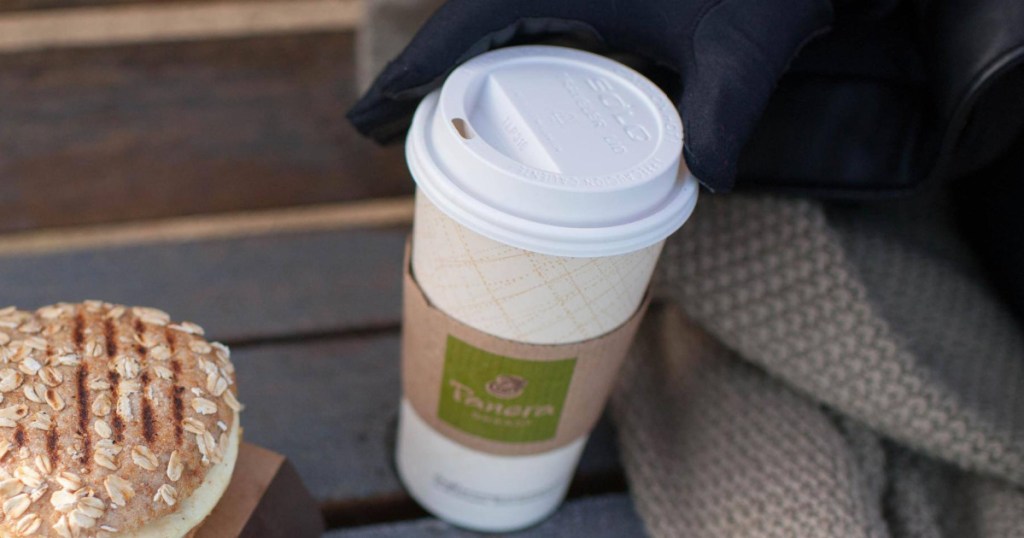 Panera Bread coffee cup on bench near breakfast sandwich