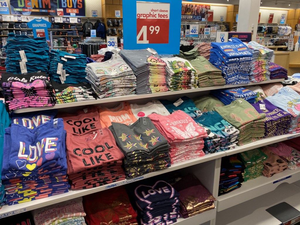 girls graphic tees folded on display table in store