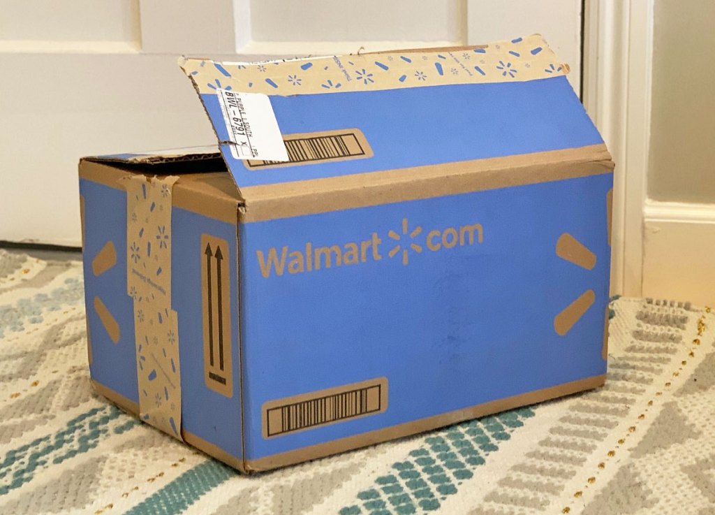 blue walmart.online shipping box on area rug near a door