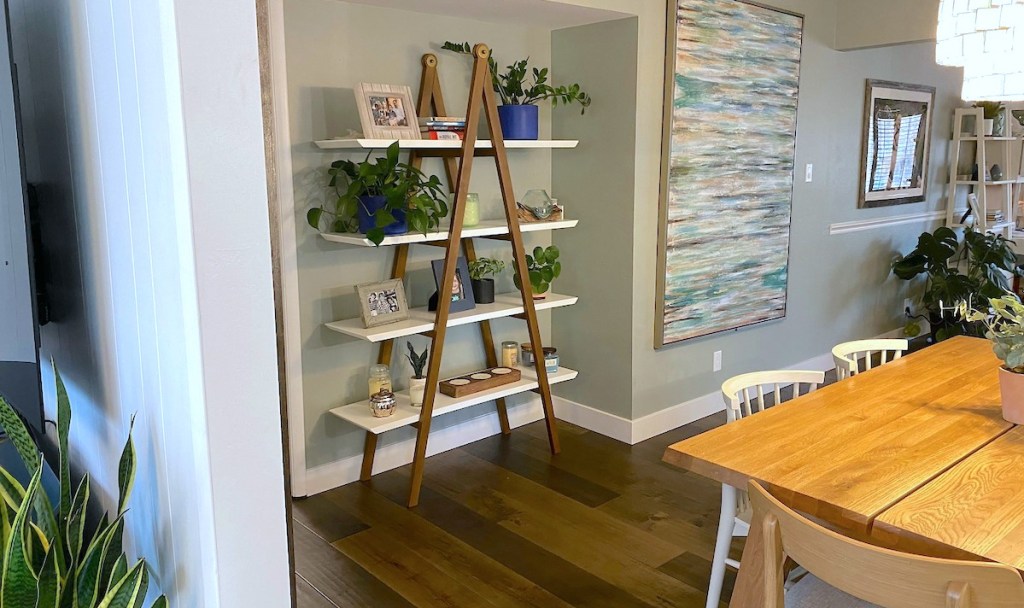 a frame article shelf sitting on wood floor in dining room with various decor