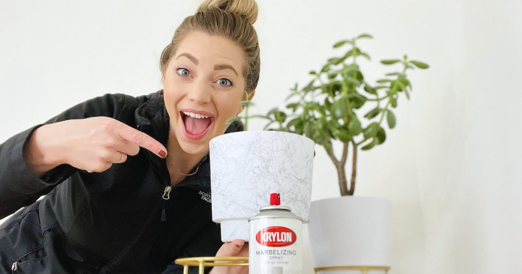 woman holding white marble spray paint planter