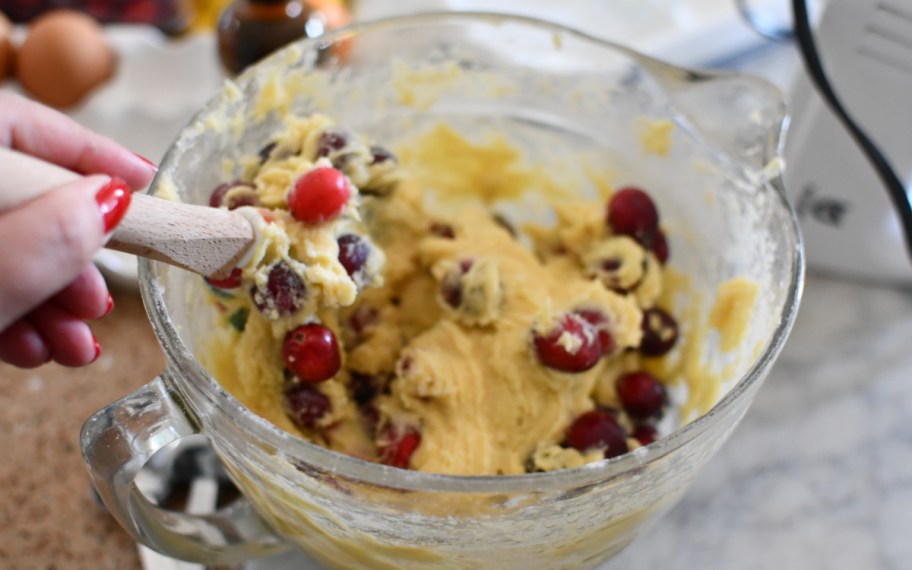 mixing cranberries into a holiday cake batter