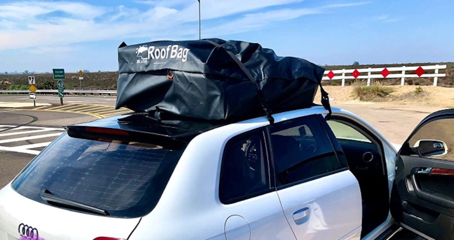 white car with black roof bag on top sitting outside, one of the best car organization accessories and ideas