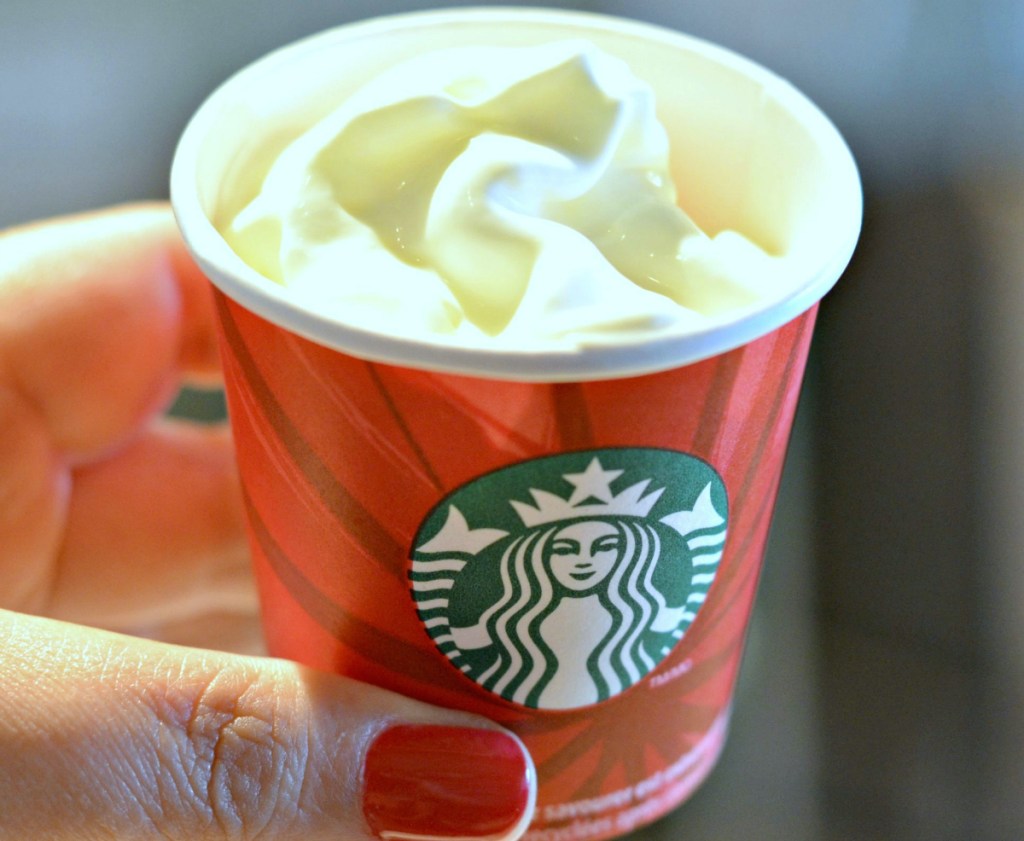 hand holding a puppuccino from starbucks