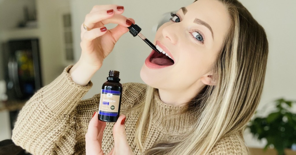 woman using dropper for elderberry extract