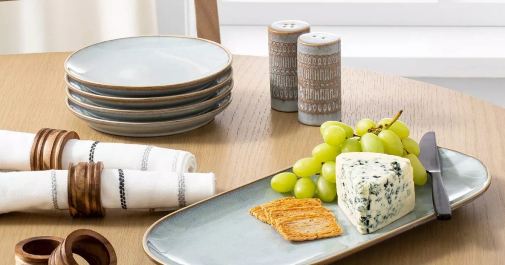 table with hearth and hand blue stone plates and seving plate with grapes and cheese