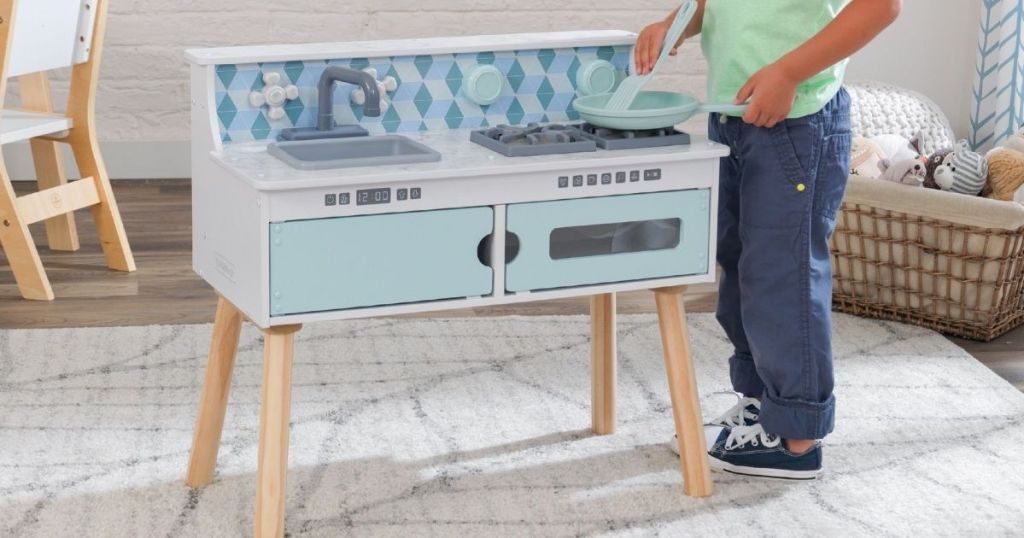 boy playing with a toy kitchen