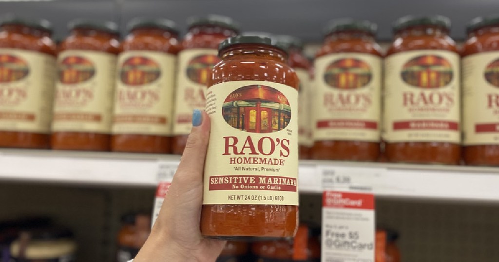 woman's hand holding marinara sauce in store